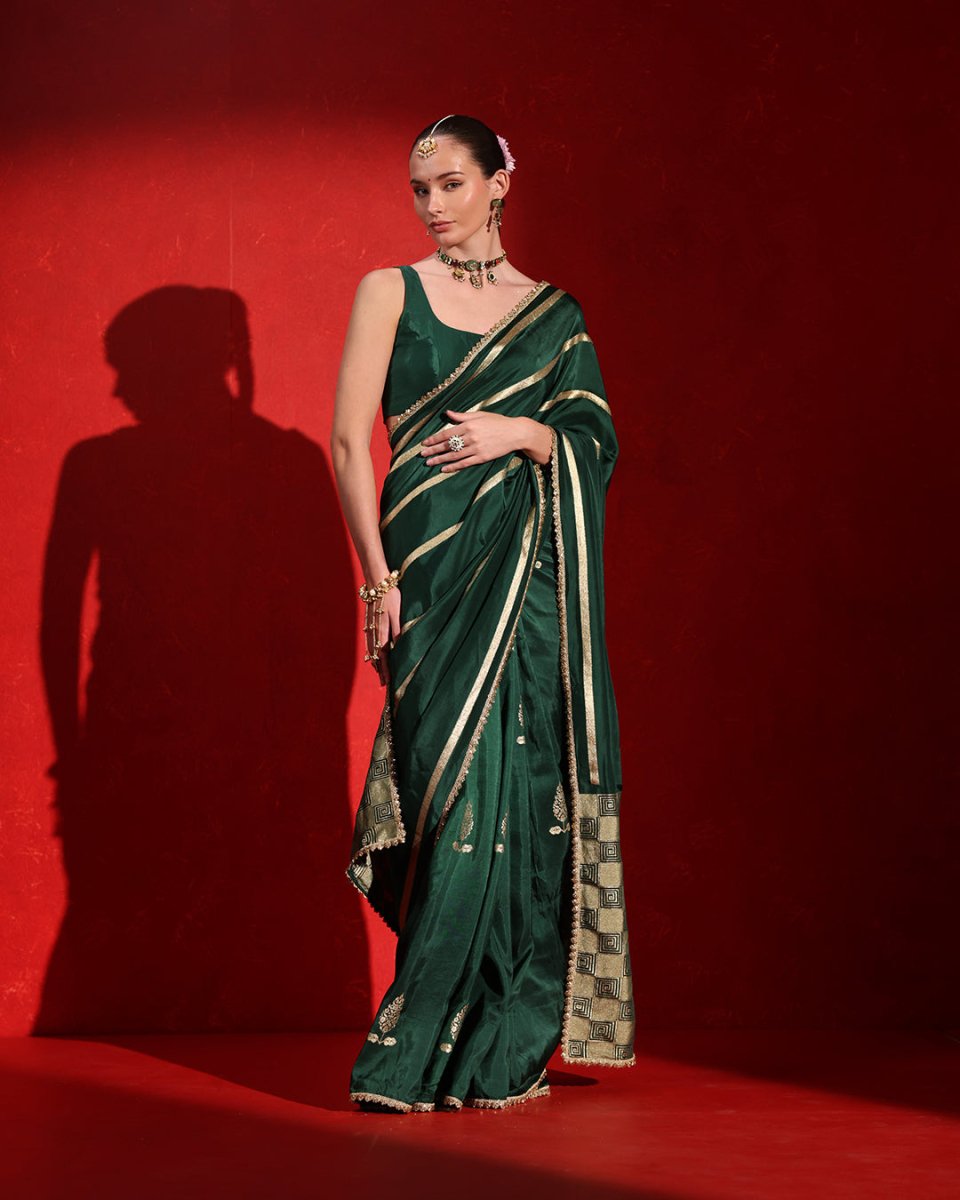Bottle Green Sleeveless Blouse Saree by Agapi Clothing featuring a modern blouse design, elegant drape, and luxurious Indian ethnic wear for weddings and festive celebrations.